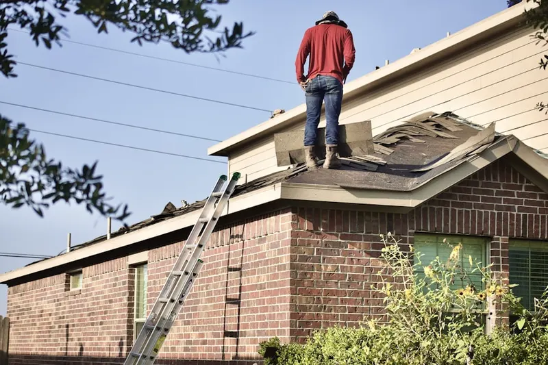 Professional roofer working on a residential roof in West Wauregan